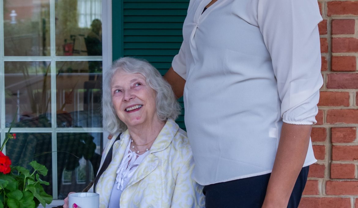 Memory care resident with Alzheimer's disease smiling at staff member
