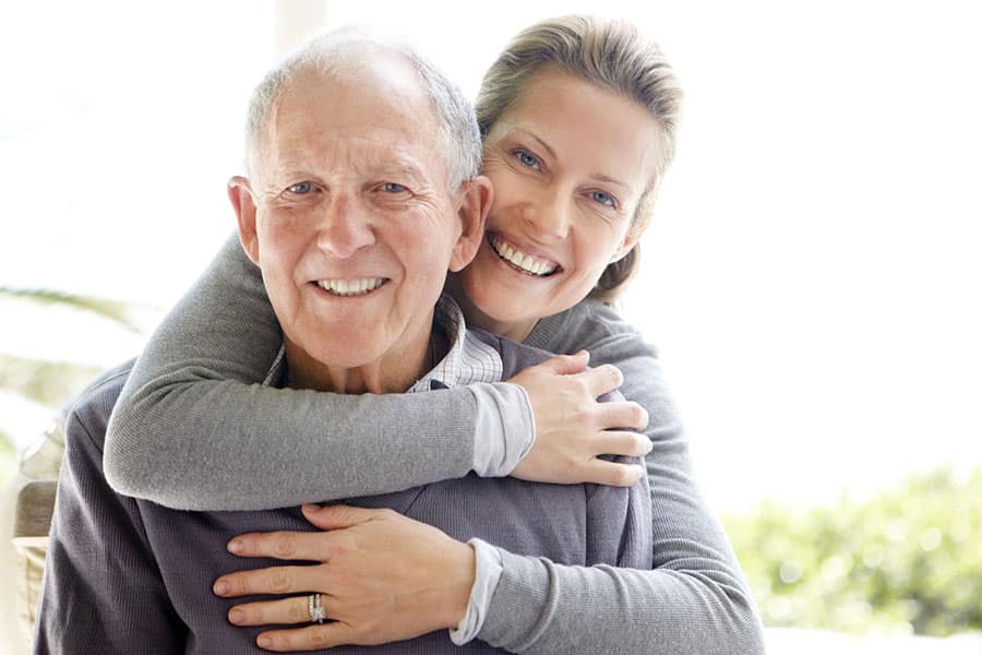 Daughter hugging her senior dad.