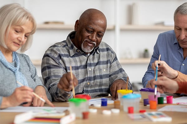 Group of seniors doing painting activities at the memory care home.