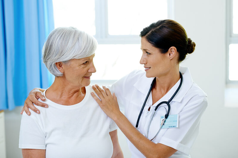 Doctor comforting an older woman during a consultation about how is Alzheimer's disease diagnosed.