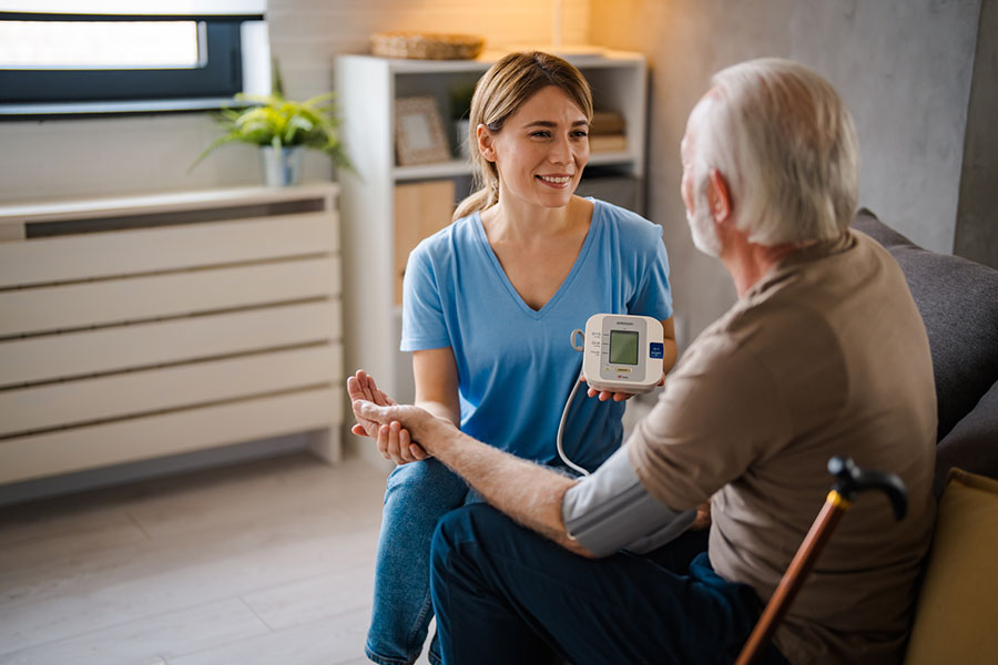 caregiver checking the blood pressure of a senior resident at an assisted living in Rockville, MD