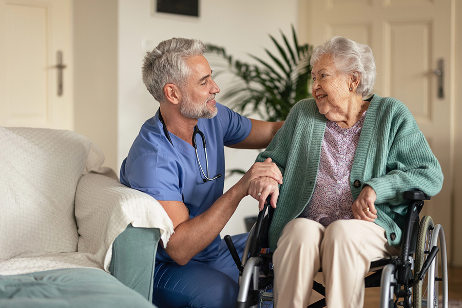 Caregiver assisting an older woman in a wheelchair, highlighting support for dementia symptoms and mild cognitive impairment.