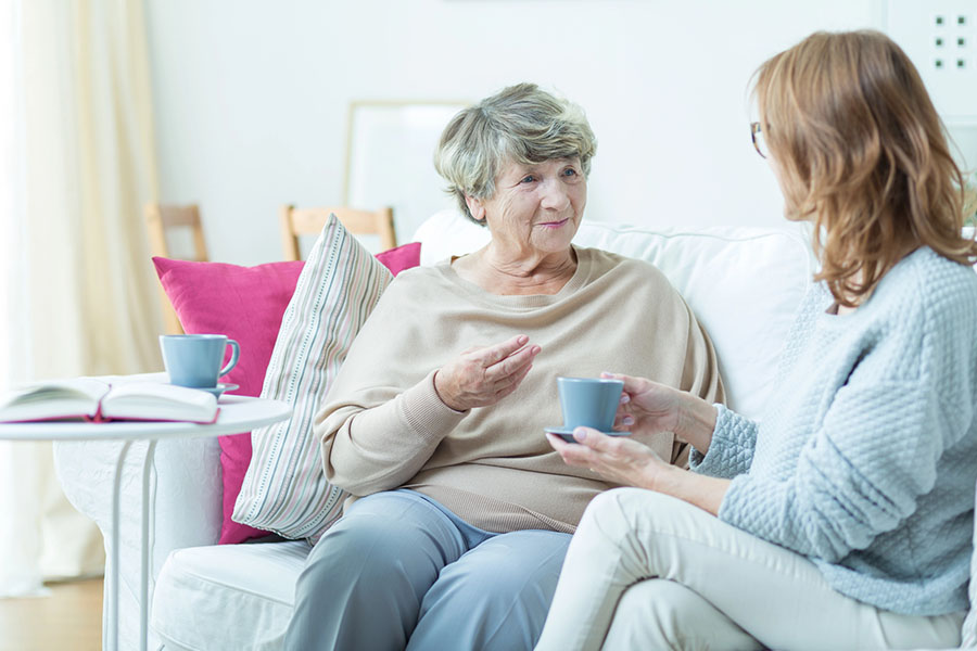 Older woman with daughter talking over tea at home, showing dementia eyes during a supportive conversation Older woman with daughter talking over tea at home, showing dementia eyes during a supportive conversation