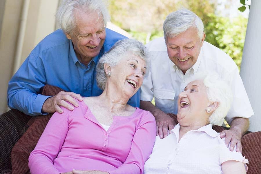 Seniors laughing together outdoors, reflecting the peace of mind provided by elderly medication safety.