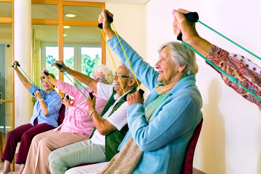 mental and physical health seniors doing seated resistance band exercises together in a group class mental and physical health seniors doing seated resistance band exercises together in a group class