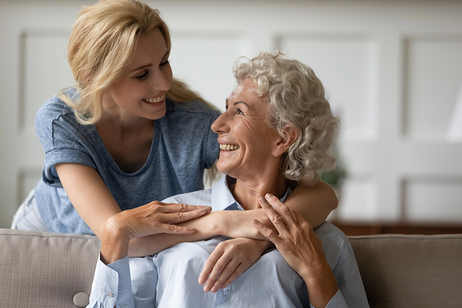 Adult child and senior parent enjoying quality time together in a comfortable living room setting.