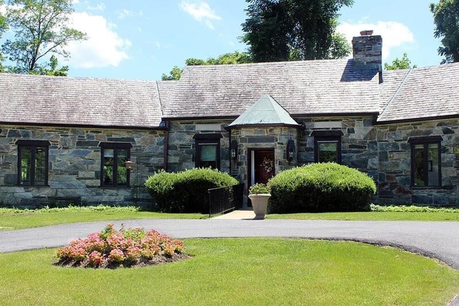 Exterior stone facade and manicured lawn at Cedar Glen residential memory care home in Rockville MD